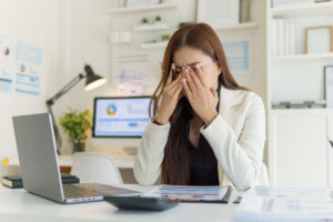 overwhelmed female looking at a blank computer screen to configure oms setup for Audiology clinic
